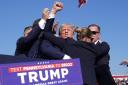 Republican presidential candidate former President Donald Trump is surrounded by U.S. Secret Service agents after the shooting