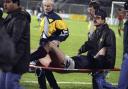 Scotland striker Ally McCoist is removed from the field on a stretcher after suffering a serious injury.