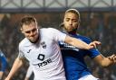 Cyriel Dessers and Josh Reid battle for the ball at Ibrox