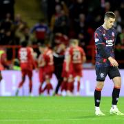 Rangers' Tom Lawrence (right) looks frustrated as Aberdeen's Shayden Morris (hidden) celebrates scoring their side's second goal of the game with team-mates during the William Hill Premiership match at Pittodrie Stadium, Aberdeen. Picture date: Wednesday